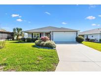 Charming single-story home featuring a well-manicured lawn and a two-car garage at 706 Jason Dr, Lady Lake, FL 32159