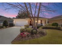 Charming single-story home with a well-manicured lawn and beautiful landscaping at sunset at 9895 Sw 95Th Loop, Ocala, FL 34481