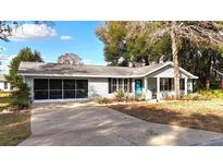 Charming single story home featuring screened in garage, well maintained landscaping and a pop of color with a blue front door at 10823 Sw 83Rd Ave, Ocala, FL 34481