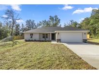 Charming single-story home with a well-maintained front yard and a two-car garage at 14 Water Track Ct, Ocala, FL 34472