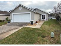 Charming single-story home featuring a two-car garage, well-maintained lawn, and neutral exterior paint at 1917 Nw 50Th Cir, Ocala, FL 34482