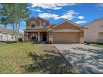 Charming two-story home with front yard, covered porch, and two-car garage at 3999 Sw 51St Ct, Ocala, FL 34474