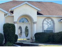 Elegant front entrance featuring a double door and arched window, flanked by well-maintained landscaping at 5500 Nw 23Rd Pl, Ocala, FL 34482