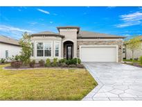 Beautiful front exterior featuring stone accents, a well-manicured lawn and an eye catching driveway at 5728 Sw 90Th Court Rd, Ocala, FL 34481