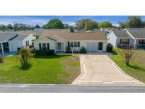 Charming single-story home with well-manicured lawn and decorative concrete driveway at 912 Chula Ct, Lady Lake, FL 32159