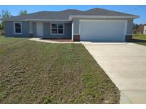 Charming single-story home featuring a two car garage, concrete driveway, and well manicured lawn at 2 Walnut Run, Ocala, FL 34472