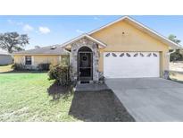 Charming single-story home featuring a stone entryway and attached two-car garage at 2620 Sw 152Nd Ln, Ocala, FL 34473