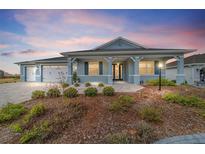 Charming one-story home with blue exterior, landscaped front yard, and attached two-car garage at 8107 Sw 92Nd Cir, Ocala, FL 34481