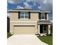 Two-story home featuring a large garage, neutral stucco, dark shutters, and a well-manicured lawn at 8673 Sw 44Th Ter, Ocala, FL 34476