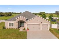 Charming single-story home featuring a two-car garage and manicured front lawn at 9105 Se 55Th Ter, Ocala, FL 34480