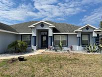 Charming single-story home featuring a light blue exterior, dark blue trim, and well-kept landscaping at 10100 Se 69Th Ave, Belleview, FL 34420