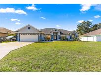 Charming single-story home with lush front lawn, blue trim, and well-manicured landscaping at 10100 Se 69Th Ave, Belleview, FL 34420