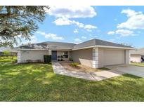 Charming single-story home featuring a well-manicured lawn and attached two-car garage at 5910 Sw 89Th St, Ocala, FL 34476