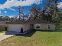 Charming single-story home featuring a two-car garage and well-maintained lawn at 6950 Se 124Th Ln, Belleview, FL 34420