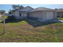 Well-maintained single story home with a one car garage and front yard with manicured bushes at 10831 Se 50Th Ter, Belleview, FL 34420