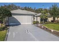 Charming single Gathering home featuring a spacious driveway with a stylish compass design at 13340 Se 86Th Cir, Summerfield, FL 34491