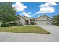 Charming home featuring a well-maintained lawn, mature trees, and a two-car garage at 7151 Sw 96Th Ct, Ocala, FL 34481