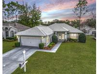 Charming single-story home with well-manicured lawn, mature trees, and attached two-car garage at 7340 Sw 111Th Ln, Ocala, FL 34476