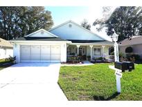 Charming single-story home with a two-car garage, well-maintained lawn, and a cozy front porch at 11091 Sw 73Rd Ct, Ocala, FL 34476