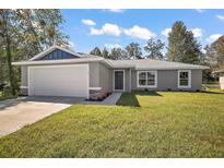 Charming single-story home features a two-car garage, green lawn, and stylish gray exterior at 206 Emerald Rd, Ocala, FL 34472