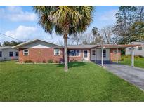 Charming brick home featuring a well-manicured lawn and a convenient carport at 21615 Sw Raintree St, Dunnellon, FL 34431