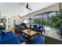 Large screened patio with multiple seating areas, a grill, and access to the pool for seamless indoor-outdoor living at 4103 Se 10Th Ave, Ocala, FL 34480