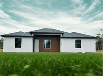 Beautiful single-story home boasting a modern design, fresh green grass, and a well-manicured lawn at 4524 Sw 110Th St, Ocala, FL 34476