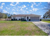 Charming single-story home with a well-maintained lawn and an attached two-car garage at 4858 Sw 143Rd Loop, Ocala, FL 34473