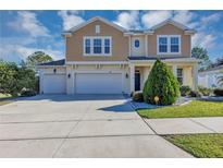 Charming two-story home with three-car garage and beautifully landscaped front yard under a sunny sky at 5417 Sw 49Th Ave, Ocala, FL 34474