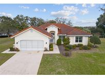 Charming home with a red tile roof, well-manicured landscaping, and an inviting front entrance at 8223 Sw 113Th Ln, Ocala, FL 34481