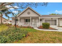 Charming home featuring a covered porch with decorative accents and a well-maintained landscaped yard at 8645 Sw 94Th Ln # A, Ocala, FL 34481