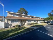 Tan siding adorns this multi-Gathering building, complemented by a well-maintained lawn and ample parking spaces at 11001 Se Sunset Harbor Rd # A08, Summerfield, FL 34491