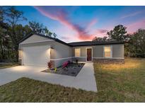 Charming single Gathering home with a manicured lawn and welcoming front entrance at 13568 Se 101St Ter, Belleview, FL 34420