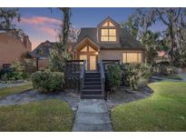 Charming two-story home featuring a symmetrical roof, complimented by a cozy front porch with inviting steps and lush shrubbery at 1621 Ne 2Nd St # 601, Ocala, FL 34470