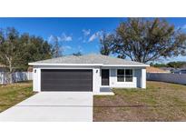 Charming single-story home features a gray roof, gray garage door, and light gray stucco exterior at 509 Marion Oaks Trail, Ocala, FL 34473