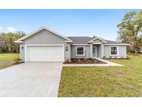 Charming single-story home featuring a two-car garage, landscaped front yard, and neutral stucco exterior at 5910 Sw 111Th Place Rd, Ocala, FL 34476