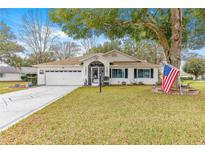 Charming single-story home with a well-maintained lawn, two-car garage, and an inviting entryway at 6450 Sw 83Rd Ln, Ocala, FL 34476
