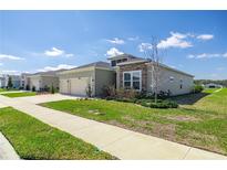 Landscaped single-Gathering home featuring a two-car garage at 7374 Sw 77Th Ave, Ocala, FL 34481
