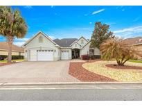 Charming home with a three-car garage, well-manicured landscaping, and a brick driveway at 8782 Sw 82Nd Court Rd, Ocala, FL 34481