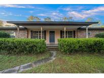 Charming single-story home with brick accents, a covered porch, and lush landscaping at 4040 E Fort King St, Ocala, FL 34470