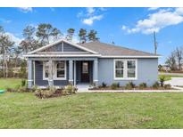 Charming single-story home with blue siding, manicured lawn, and fresh landscaping at 10512 Sw 49Th Avenue Rd, Ocala, FL 34476
