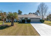 Charming single-story home with a well-manicured front yard, mature landscaping, and a two-car garage at 13677 Sw 40Th Avenue Rd, Ocala, FL 34473