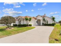 Charming stucco home with a well-manicured lawn and a long driveway at 2399 Nw 53Rd Avenue Rd, Ocala, FL 34482