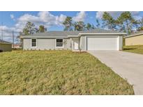 Charming single-story home featuring a well-manicured lawn and an attached two-car garage at 7772 Sw 146Th Lane Rd, Ocala, FL 34473
