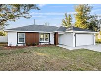 Charming single-story home featuring a well-manicured lawn and a two-car garage at 800 Marion Oaks Mnr, Ocala, FL 34473