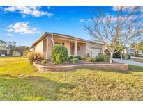 Landscaped front yard featuring lush green lawn and lovely plants at 8245 Sw 78Th Terrace Rd, Ocala, FL 34476