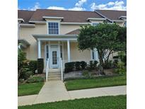 Charming townhome with a welcoming front porch, lush landscaping, and a well-maintained exterior at 162 Riggings Way, Clermont, FL 34711