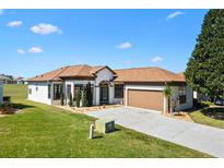 Beautiful single-story home features a manicured lawn, neutral paint scheme, and an attached two-car garage at 17818 Se 120Th Ct, Summerfield, FL 34491