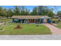 Charming single-story home featuring a well-maintained lawn and vibrant blue exterior at 1905 Nw 25Th Ave, Ocala, FL 34475