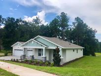 Charming single-story home with a craftsman-style front porch, white siding, and well-manicured lawn at 1955 Nw 79Th Loop, Ocala, FL 34475